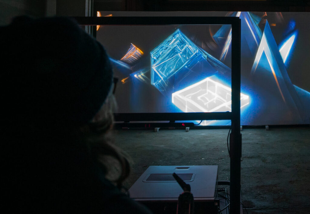 A person is looking through a frame onto an abstract projection.