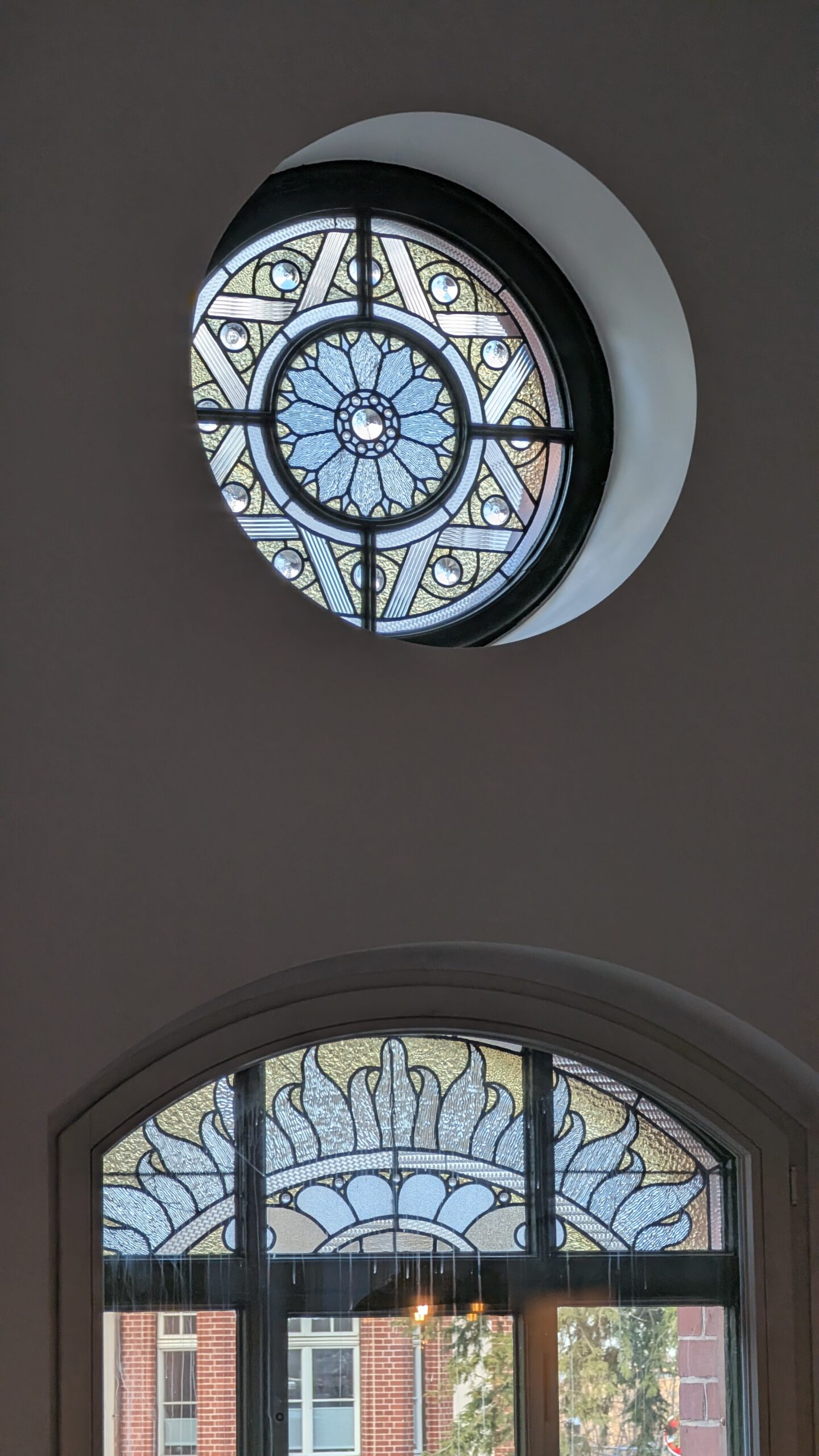A restored round window with an ornamental glass rosette pattern.
